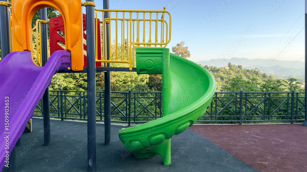 colorful playground slide set against a backdrop of lush green hills and a clear blue sky, offering a fun spot for children with a scenic view colorful playground slide set against a backdrop of lush green hills and a clear blue sky, offering a fun spot for children with a scenic view
