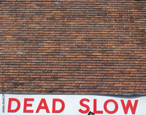 Brick Wall with Red Warning Sign