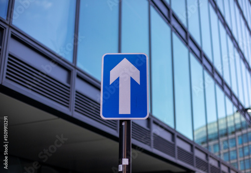 Blue Traffic Sign Against Modern Glass Building