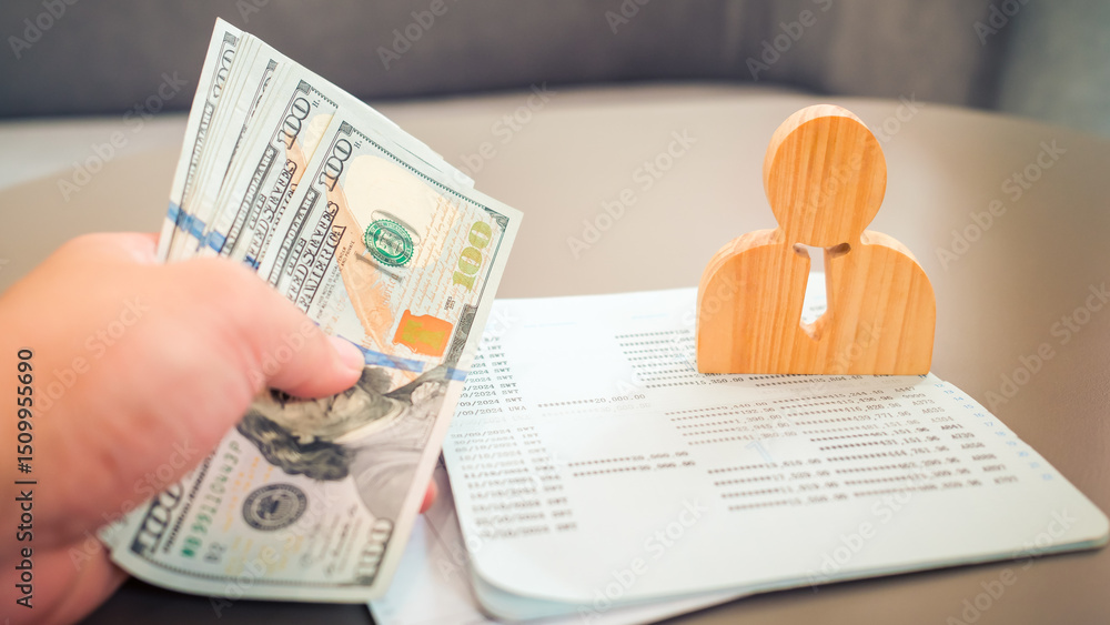 Obraz premium Boss counting dollars to pay employees' accounts in company with wooden employee model and blurred image of bankbook