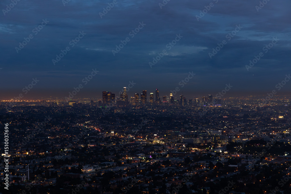Obraz premium A panoramic night view of Los Angeles showcases the city’s glowing skyline illuminated by countless lights