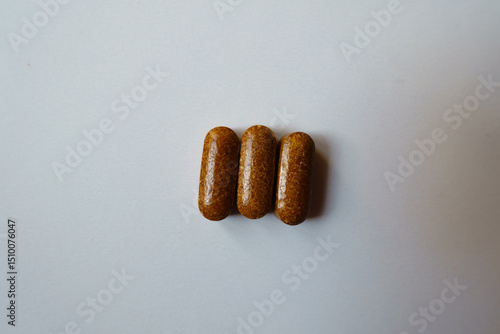 Konstfotografi Three brown caplets of iron dietary supplement from above