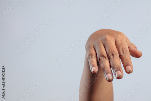 Relaxed human hand hanging downward with fingers gently drooping expressing calm gesture or passive body language against plain background