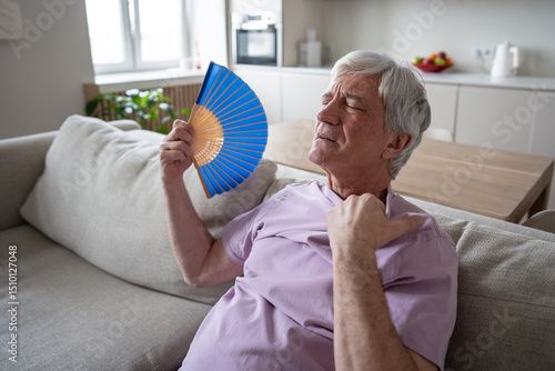 Obraz na plátne Sweating elderly man fanning suffering from suffocating heat