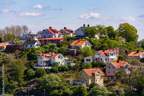 Picturesque colony of old small wooden historic houses on the Slottsberget mountain on the banks of the Gota alv river, Gothenburg, Sweden, sunny day