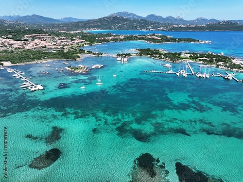 Fototapeta Naklejka Na Ścianę i Meble -  Aerial view of Marinella beach and harbour, white sand beach bathed by a beautiful turquoise water. Marinella Beach, Porto Rotondo, Costa Smeralda, Olbia, north east coast of Sardinia, Italy
