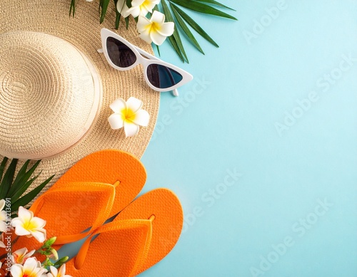 A beach hat with white-framed sunglasses and orange floral flip-flops on a light blue background.