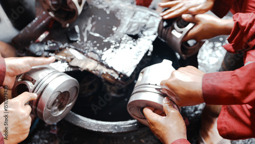Billede på lærred Several technicians are cleaning the piston head by hand using sandpaper and oil during the maintenance and overhaul process of a truck engine