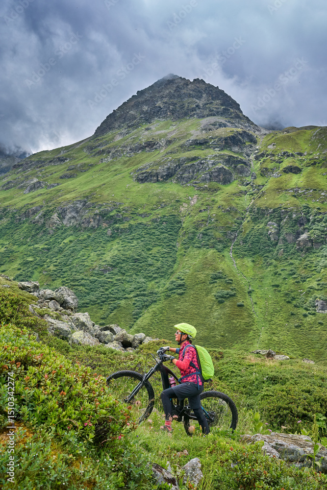 Obraz premium nice active senior woman riding her electric mountain bike in the silvretta mountain range near Gaschurn, Tyrol, Austria