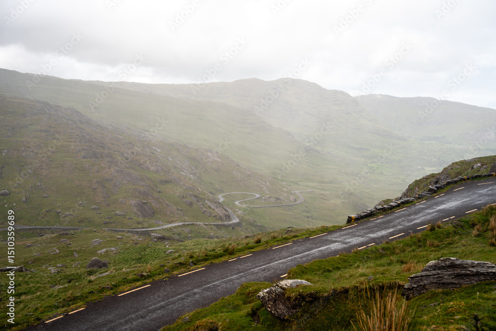 Fototapeta premium Gewundene Straße durch die raue Berglandschaft Irlands Healy Pass in der grünen Berglandschaft Irlands