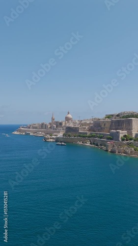 Wallpaper Mural Vertical drone shot capturing a yacht gliding past Valletta waterfront, Malta skyline rising above Torontodigital.ca