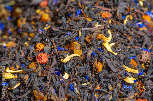 Photography A close-up of loose tea leaves highlighted with bright blue and yellow flower petals, creating a visually striking and aromatic composition