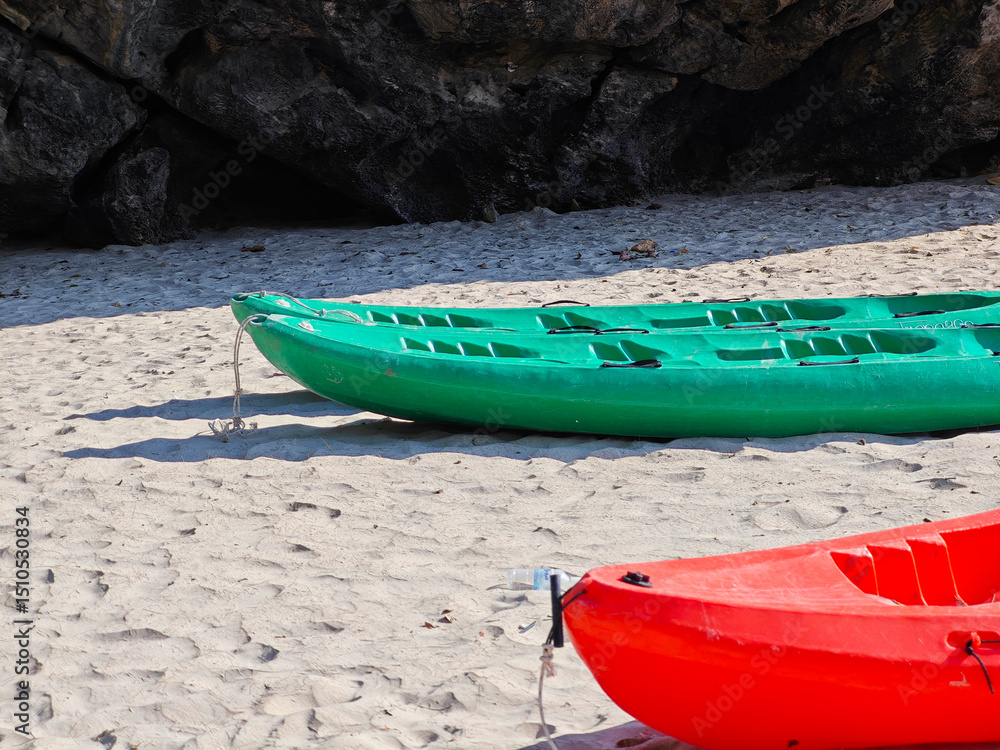 Red and green kayak on the sandy beach Red and green kayak on the sandy beach