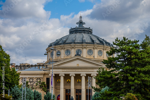 The Romanian Athenaeum Concert Hall in Bucharest, Romania Framed by Trees Under a Cloudy Sky