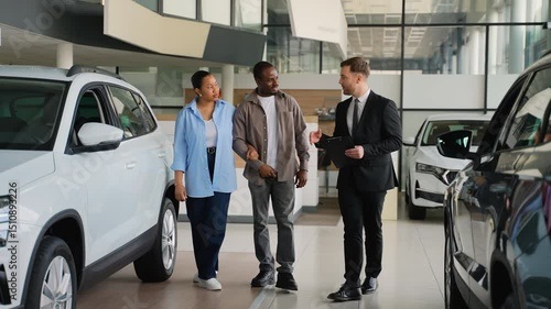 Wallpaper Mural Couple choosing new car at dealership with salesperson assistance Torontodigital.ca