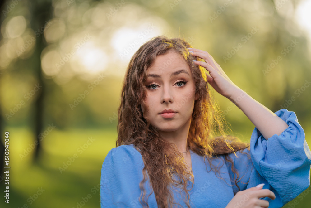 Fototapeta premium Beautiful Girl with long hair posing in sunbeams in park