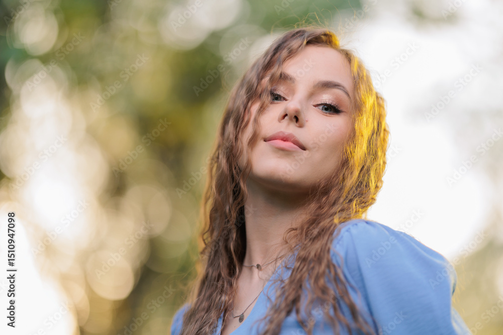 Obraz premium Beautiful Girl with long hair posing in sunbeams in park