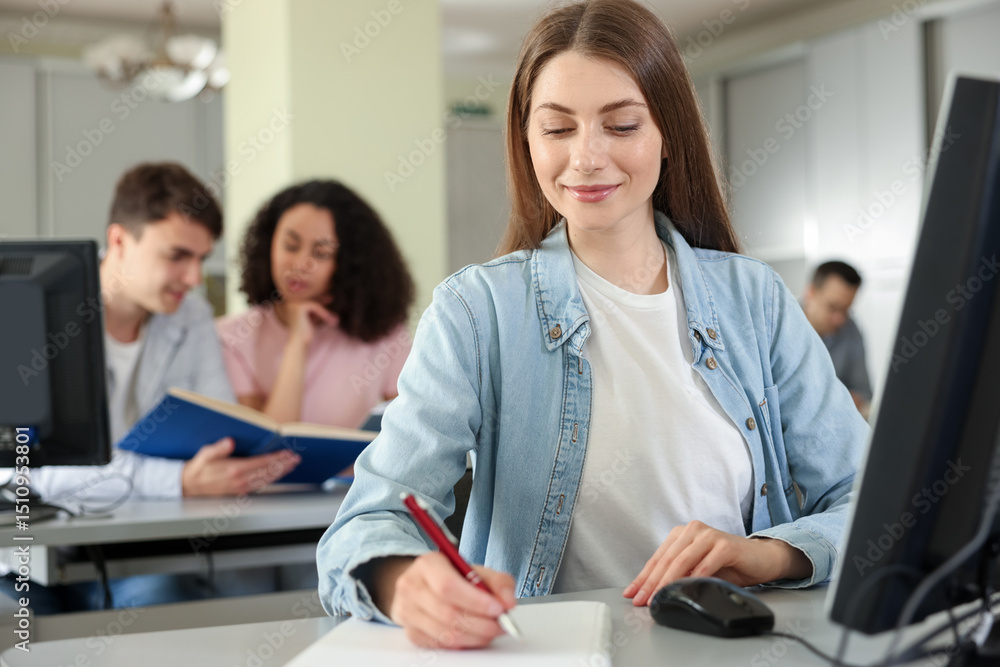 Fototapeta premium People working at desks in library, selective focus