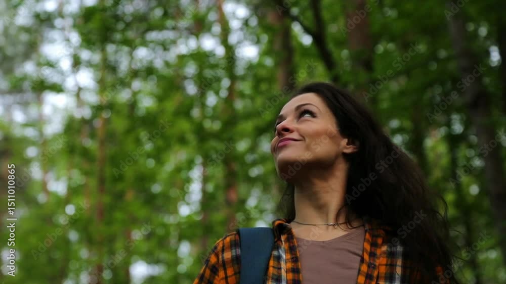 Beauty emotion woman face walking with backpack in a park. Relax girl hiking in green wood and looking above on trees on sunny autumn weather. Person coming in style fashion bright clothes. Closeup Beauty emotion woman face walking with backpack in a park. Relax girl hiking in green wood and looking above on trees on sunny autumn weather. Person coming in style fashion bright clothes. Closeup