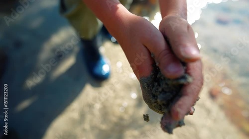 Child's hands with natural dirt on pure mountain river background