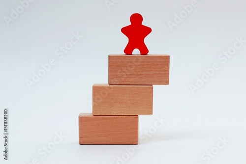 Stack of wooden blocks and human icon on top on white background
