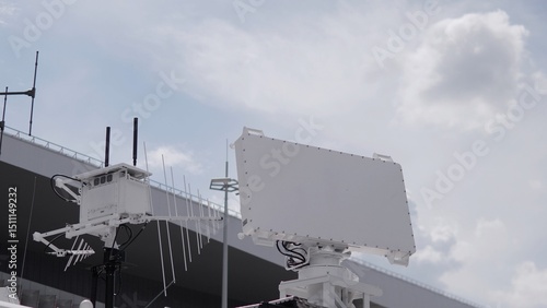 Radar systems at a military facility highlight cutting-edge technology used for surveillance and communication, set against a backdrop of a cloudy sky.