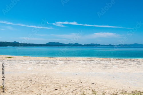 Century Beach in Nago, Okinawa—turquoise waters meet a concrete pier, with a distant cityscape beyond the horizon.