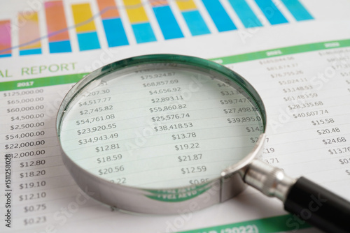 Magnifying glass on spreadsheet chart paper.