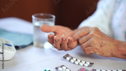 Elderly hand holding pill and glass of water, taking medication for health care and daily health management routine