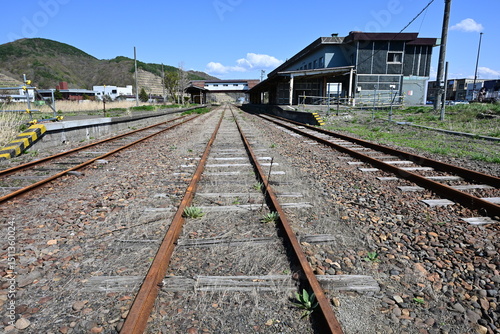 錆びたレールが伸びる廃線駅構内