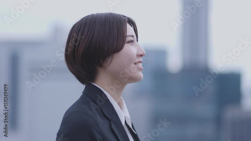 スーツを着た若い日本人女性と都会の街並み