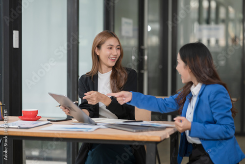 Two young female businesswomen are meeting in an office.