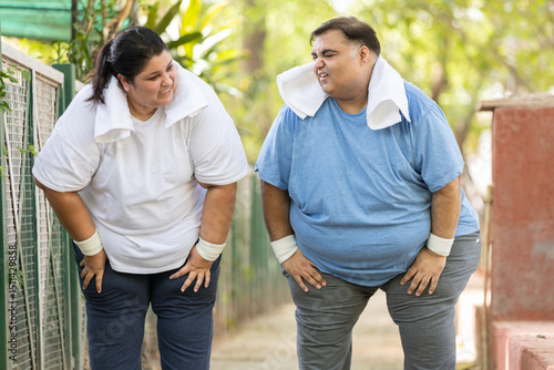 Fotografie Obesity- Fat exhausted indian couple stopped after jogging in summer park