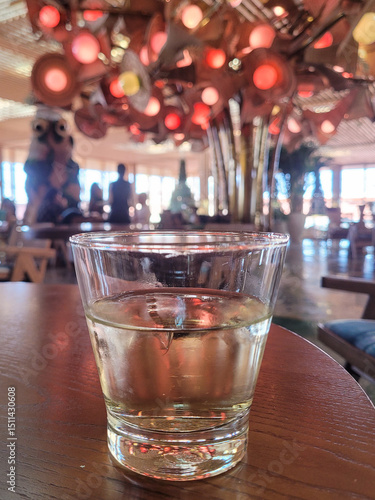 A glass of cocktail or water against a festive party background