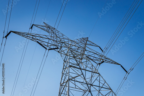 Foto Dynamic diagonal view of electrical pylon and high voltage lines under a clear b