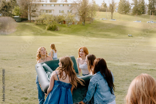 University students moving furniture on campus lawn