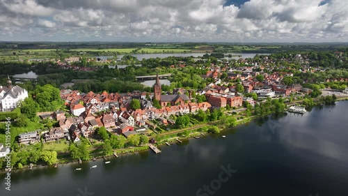 Aerial footage of historic townscape of Plön by the lake Plöner See, Schleswig-Holstein, Germany. Plön and its lake landscape. Aerial orbit of St Nicholas' church in historic town Plön.
