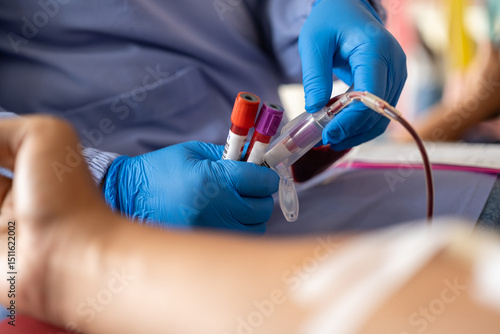 Close-up of a medical worker drawing blood into vials from a patient’s arm. Blue gloves and vacutainer system highlight sterile and professional healthcare environment.