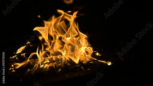 Bright orange and yellow flames dancing against a dark black background.