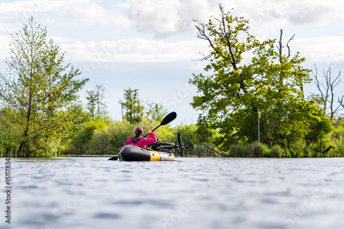 Woman Bikerafting on the Peene River in Summer Surrounded by Wild Nature