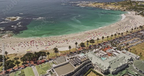 Cape Town South Africa Aerial v81 birds eye view flyover Camps Bay's white sandy beach, tilt up reveals Lion's Head, Signal Hill, and views of Clifton - Shot with Mavic 3 Pro Cine - Jan 11th 2024