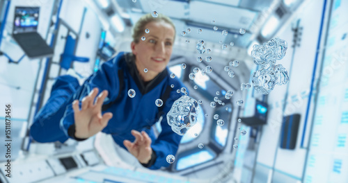 Female Cosmonaut in a Blue Suit Interacts With Floating Water Droplets Inside a Space Station, Demonstrating gravity Effects. Portrait of a Courageous Female Astronaut on Board a Spacecraft, Floating