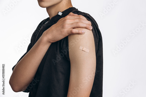 One Small Patch, One Big Step for Health
Teenager Showing Arm with Band-Aid After Vaccination in Studio...