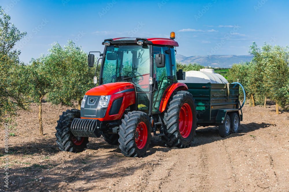 Fototapeta premium Tractor in olive grove during daytime in Andalusia, Spain