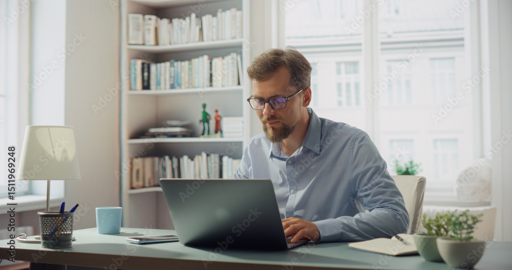 Obraz premium Creative Man Works on His Laptop at a Desk. Professional Marketing Writer Deep in Thought, Analysis and Creative Process, Focused and Creative Workspace. Starting Work