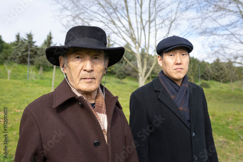 Father and son standing together in park, showing family unity