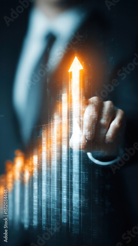 Vertical image of businessman in formal suit pointing at glowing upward arrow chart, digital interface overlay, modern tech background, concept of business growth and success