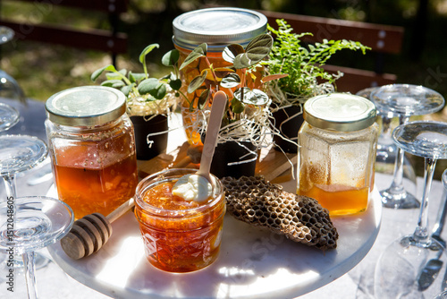 Jars of honey with wood spoons and honey dippers 