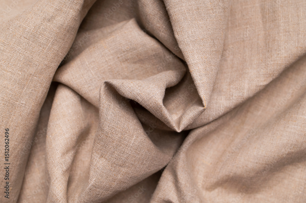 Fototapeta premium Natural beige brown linen fabric texture with folds and waves. Eco-friendly cotton material, fabric crumpled background. Fabric for sewing, clothing top view