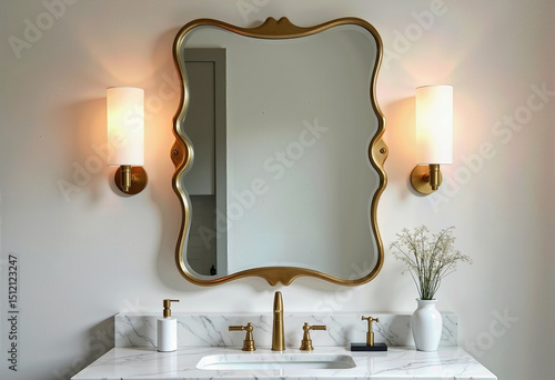 Classic Bathroom Vanity Space Showcasing a Beautifully Crafted Marble Countertop, Featuring Ornate Gold Faucets, a Scalloped Gold Frame Mirror, and Traditional Fabric Shade Sconces, Enhancing a Refine
